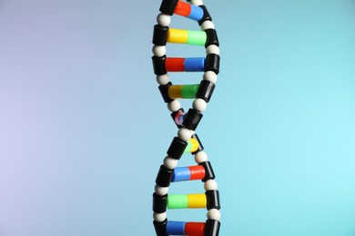 Photo of DNA structure model on color background, closeup