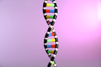 Photo of DNA structure model on color background, closeup