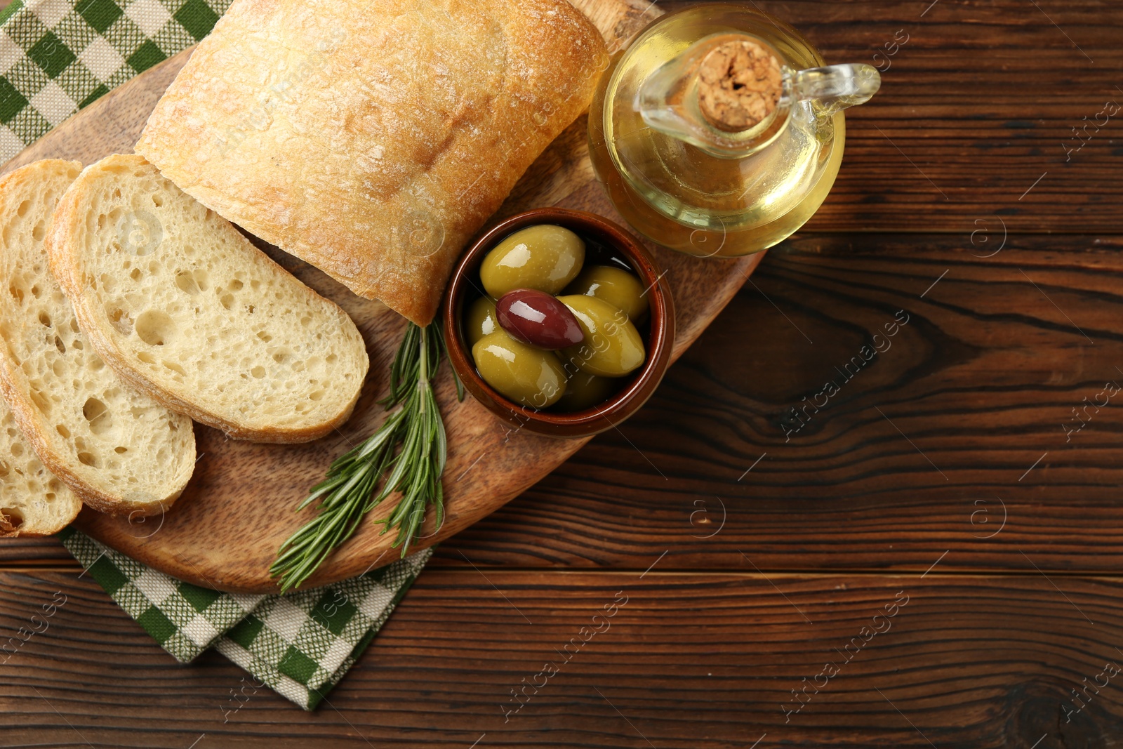 Photo of Delicious marinated olives, bread and feta cheese served on wooden table, top view