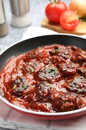 Photo of Delicious meatballs with tomato sauce and herbs in on table, closeup