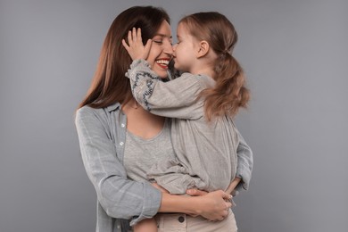 Photo of Happy mother with her cute little daughter on grey background