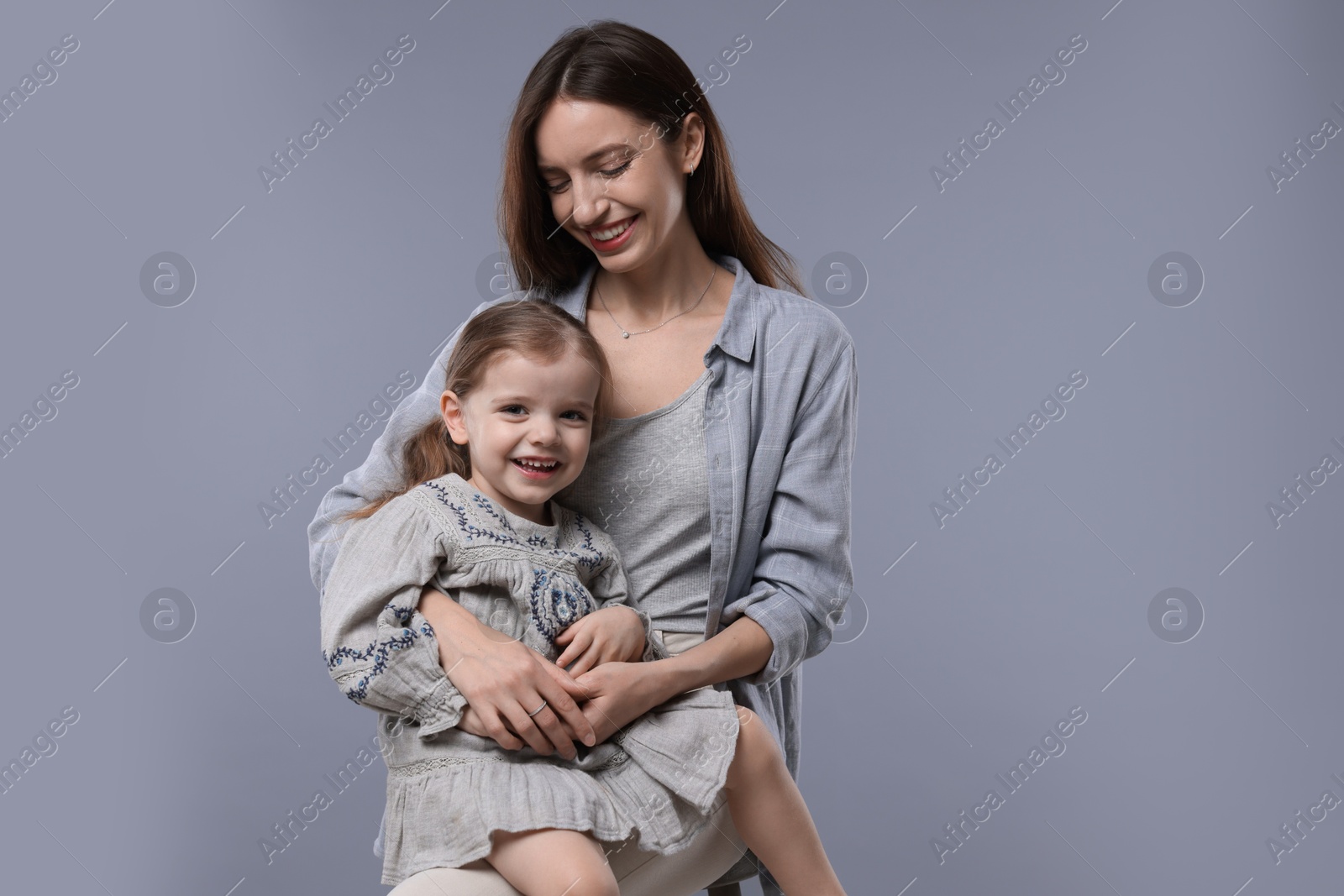 Photo of Happy mother with her cute little daughter on grey background