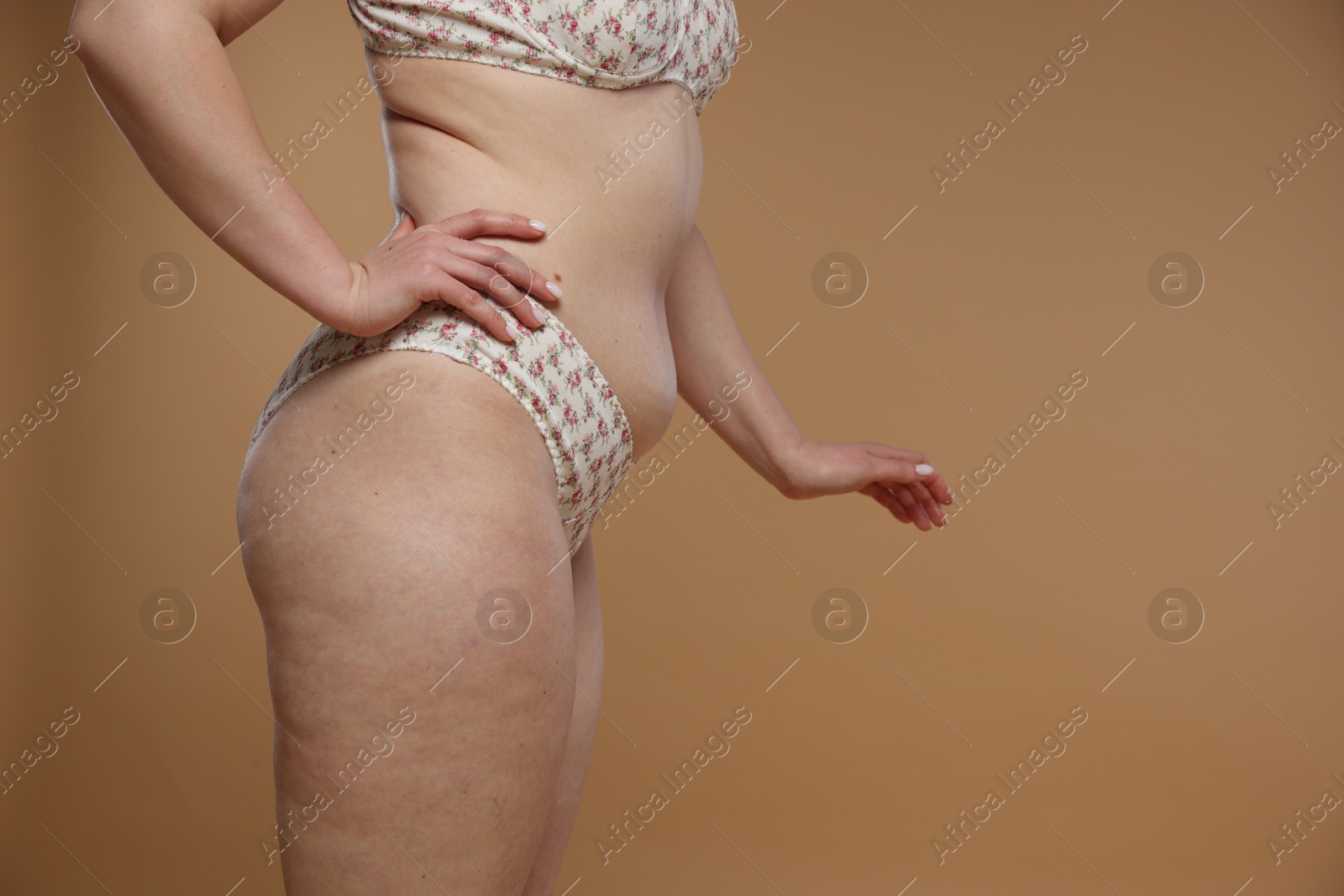 Photo of Woman with cellulite on dark beige background, closeup. Space for text