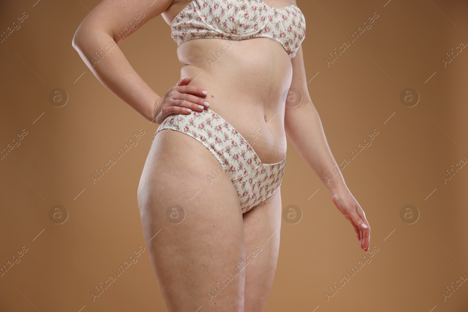 Photo of Woman with cellulite on dark beige background, closeup