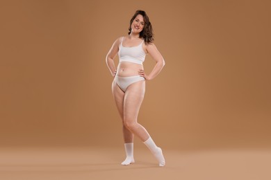 Photo of Beautiful woman in underwear on dark beige background. Cellulite problem