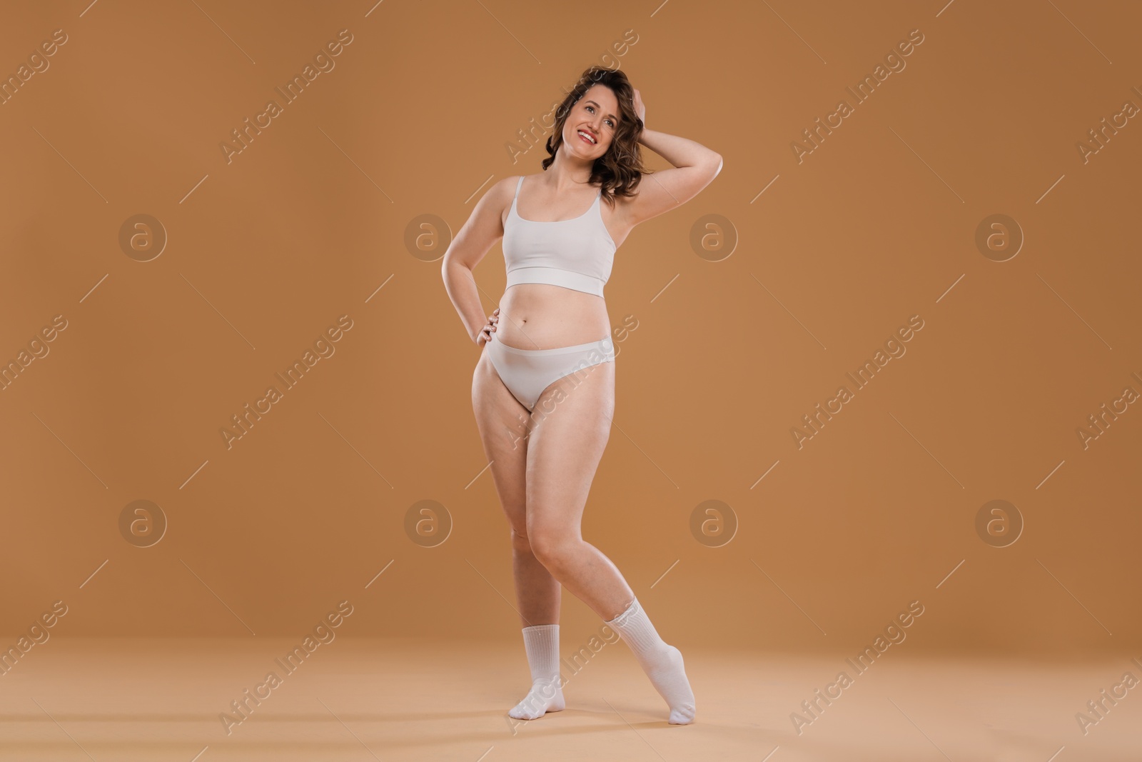 Photo of Beautiful woman in underwear on dark beige background. Cellulite problem