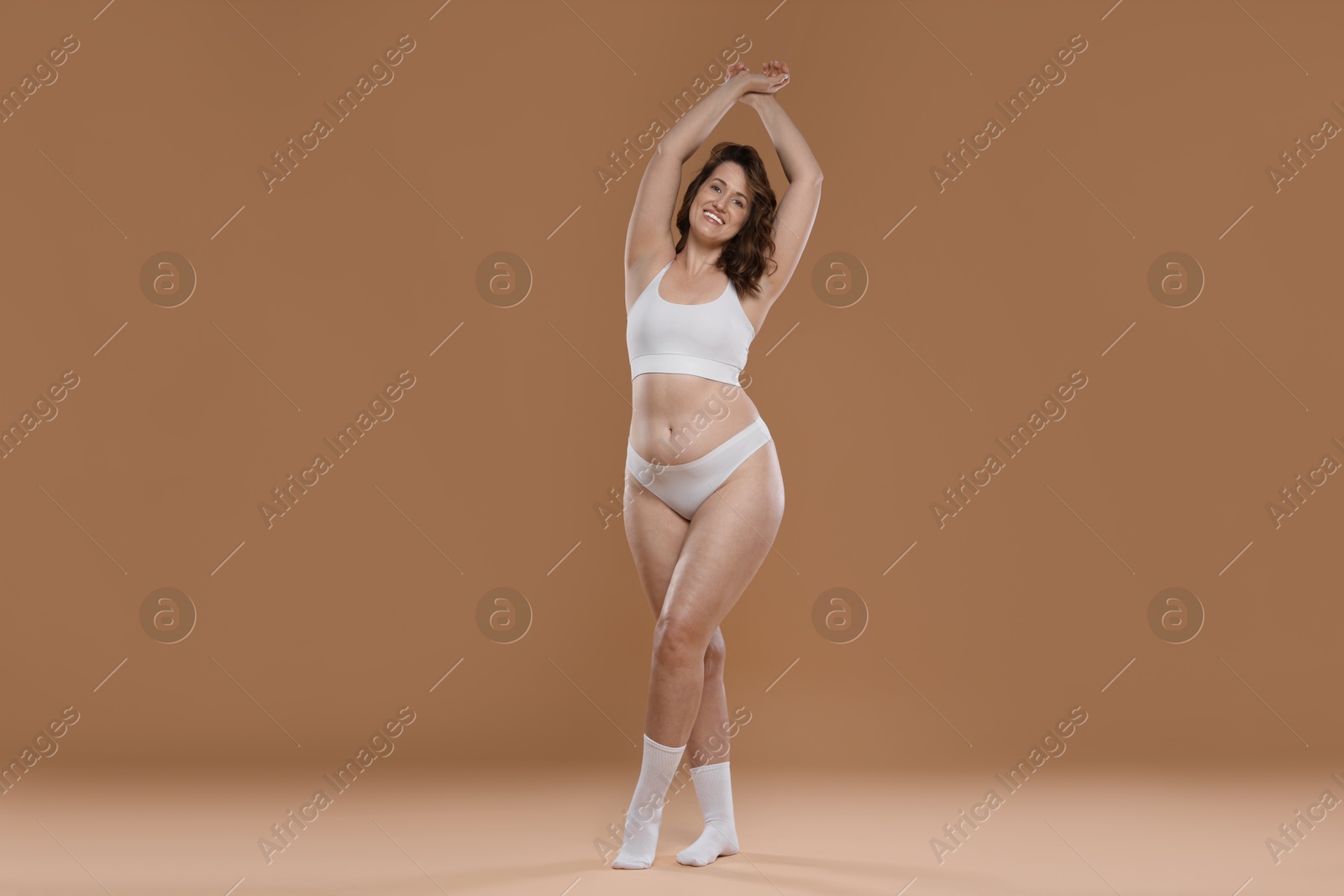 Photo of Beautiful woman in underwear on dark beige background. Cellulite problem