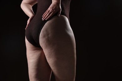 Photo of Woman with cellulite problem on black background, closeup. Space for text