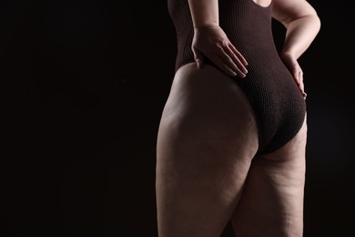 Photo of Woman with cellulite problem on black background, closeup. Space for text