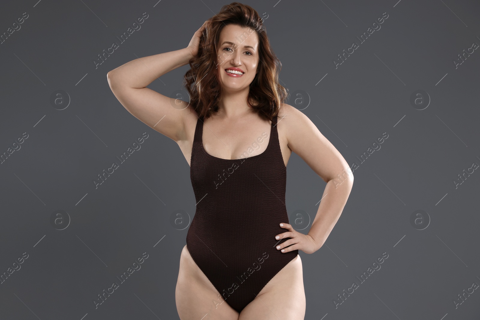 Photo of Beautiful woman in bodysuit on dark grey background. Cellulite problem