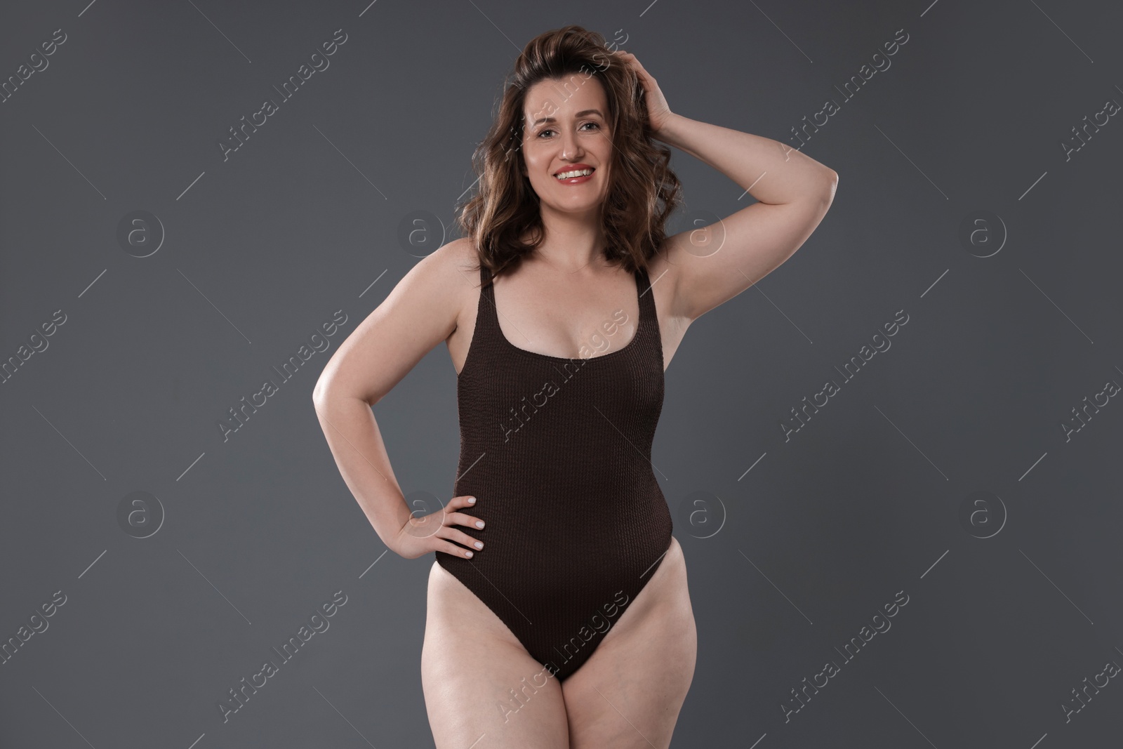 Photo of Beautiful woman in bodysuit on dark grey background. Cellulite problem