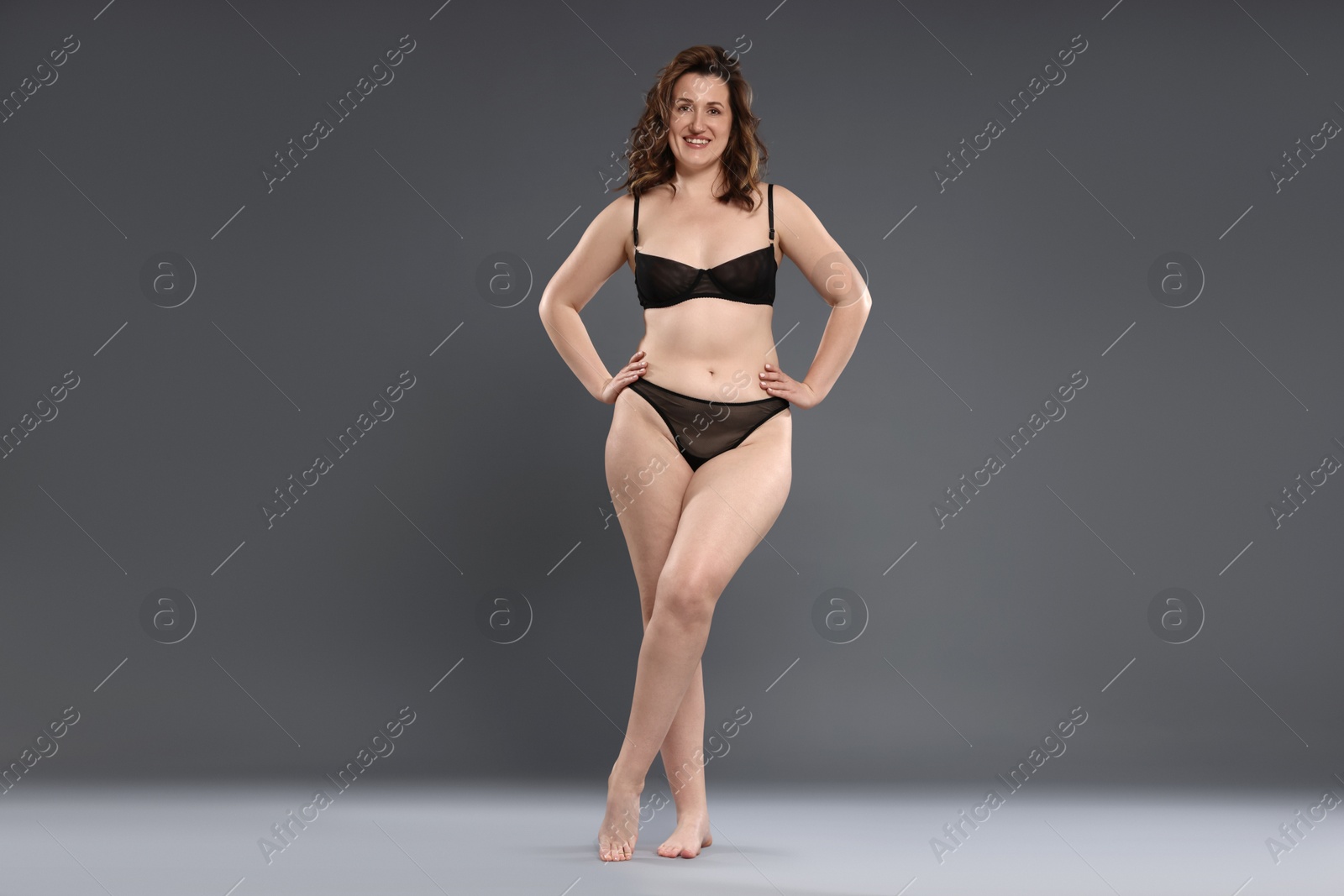 Photo of Beautiful woman in underwear on dark grey background. Cellulite problem