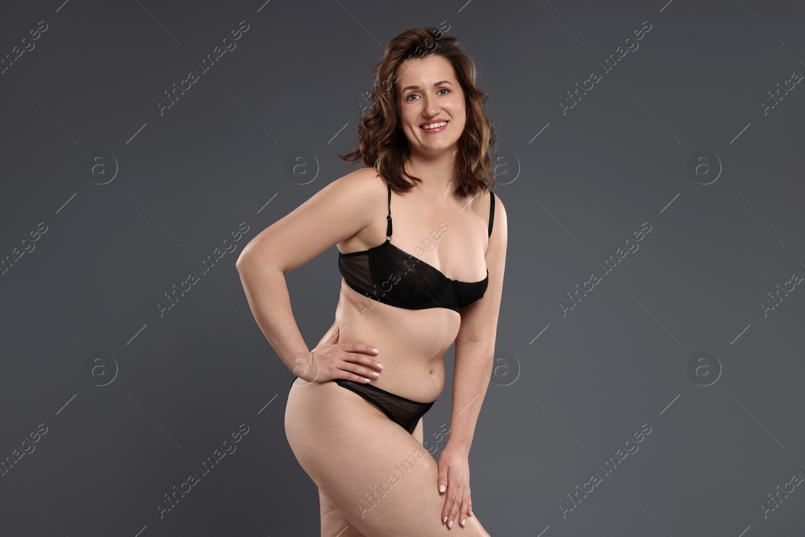 Photo of Beautiful woman in underwear on dark grey background. Cellulite problem