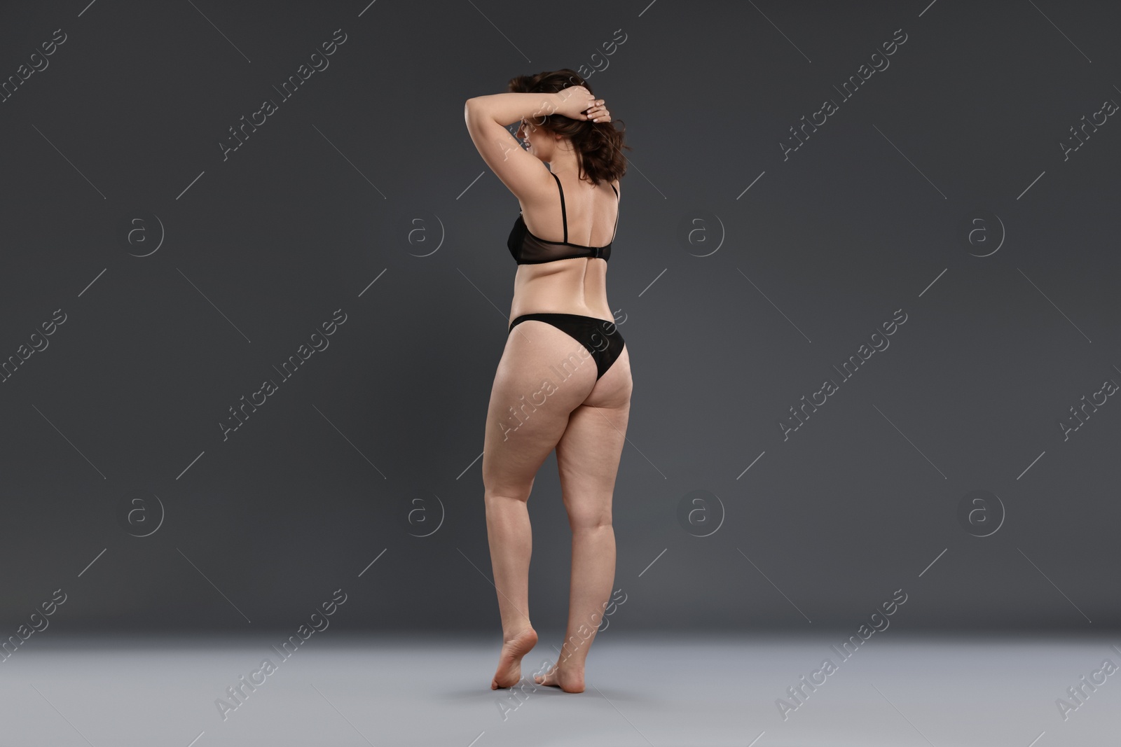 Photo of Beautiful woman in underwear on dark grey background. Cellulite problem