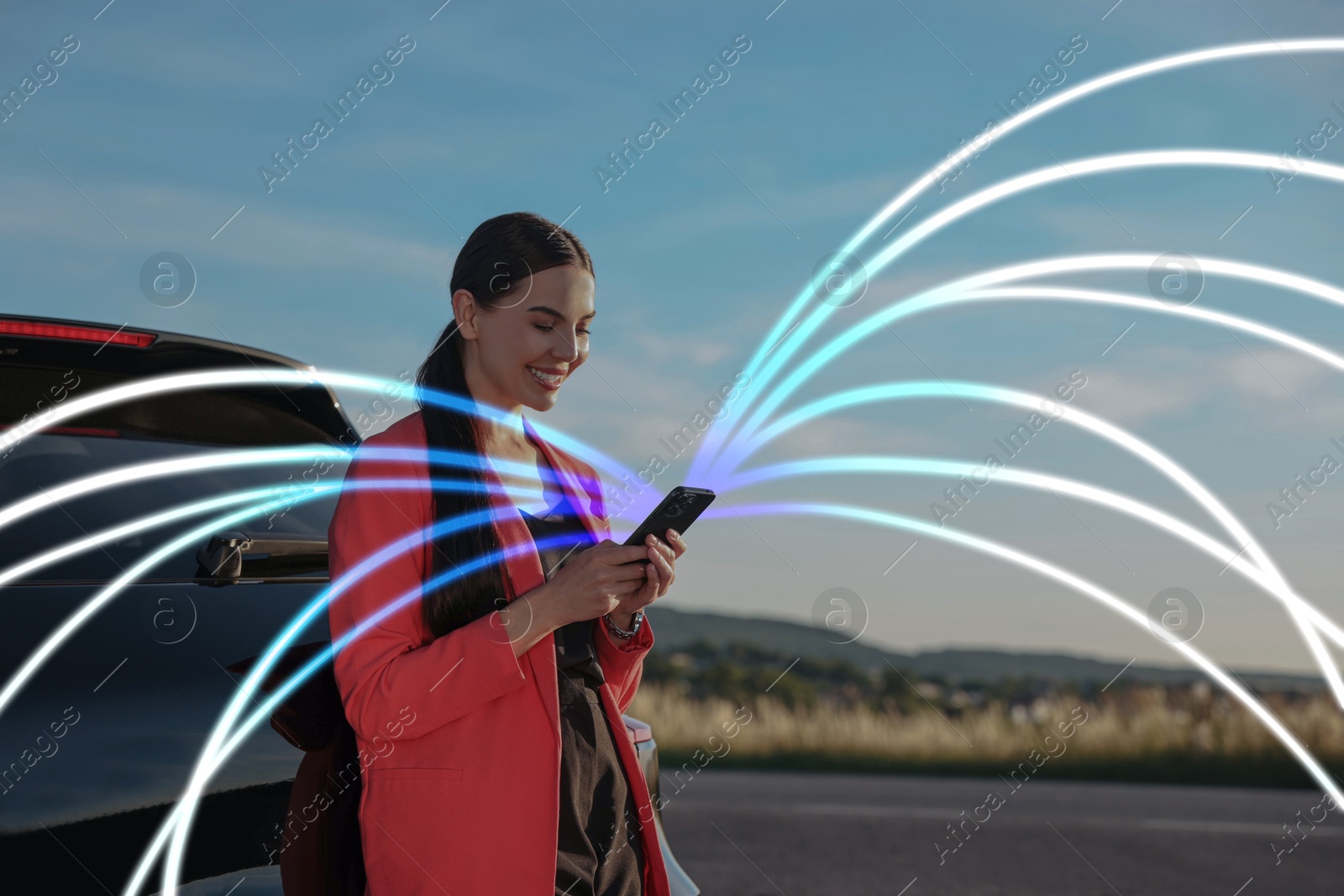 Image of Happy woman using mobile phone outdoors. Bright lines coming out of device symbolizing high speed internet