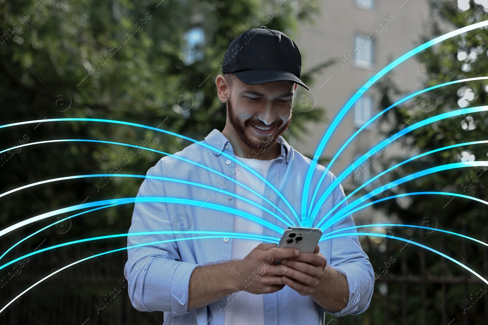 Image of Happy man using mobile phone outdoors. Bright lines coming out of device symbolizing high speed internet