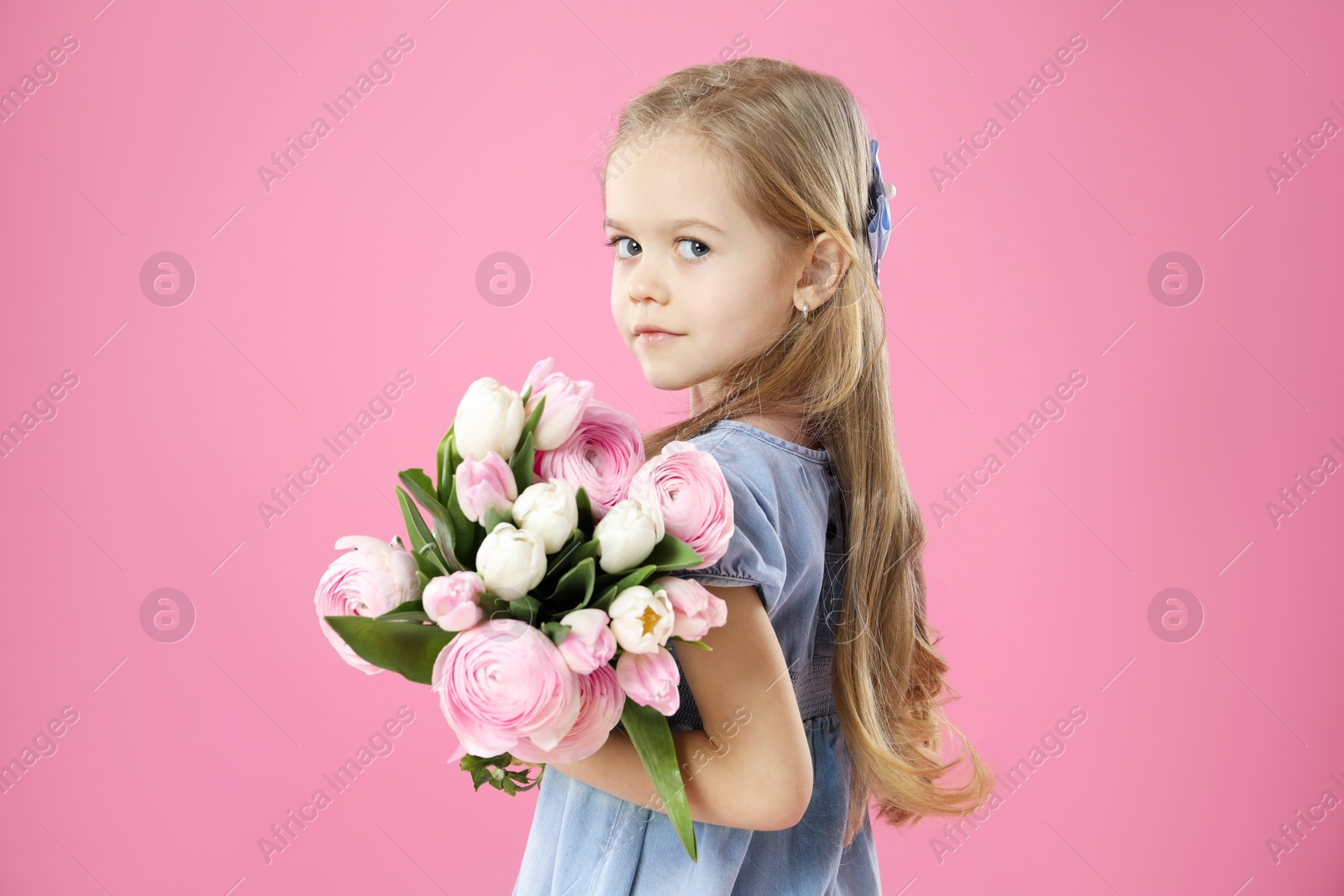 Photo of Cute little girl with bouquet of beautiful spring flowers on pink background