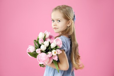 Photo of Cute little girl with bouquet of beautiful spring flowers on pink background