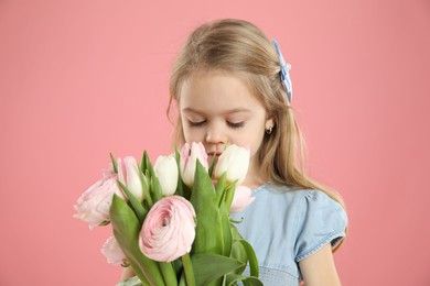 Photo of Cute little girl with bouquet of beautiful spring flowers on pink background