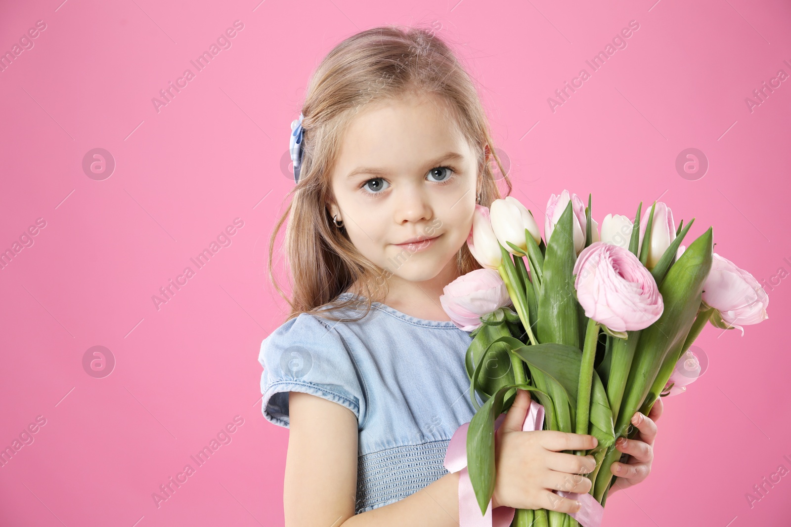 Photo of Cute little girl with bouquet of beautiful spring flowers on pink background