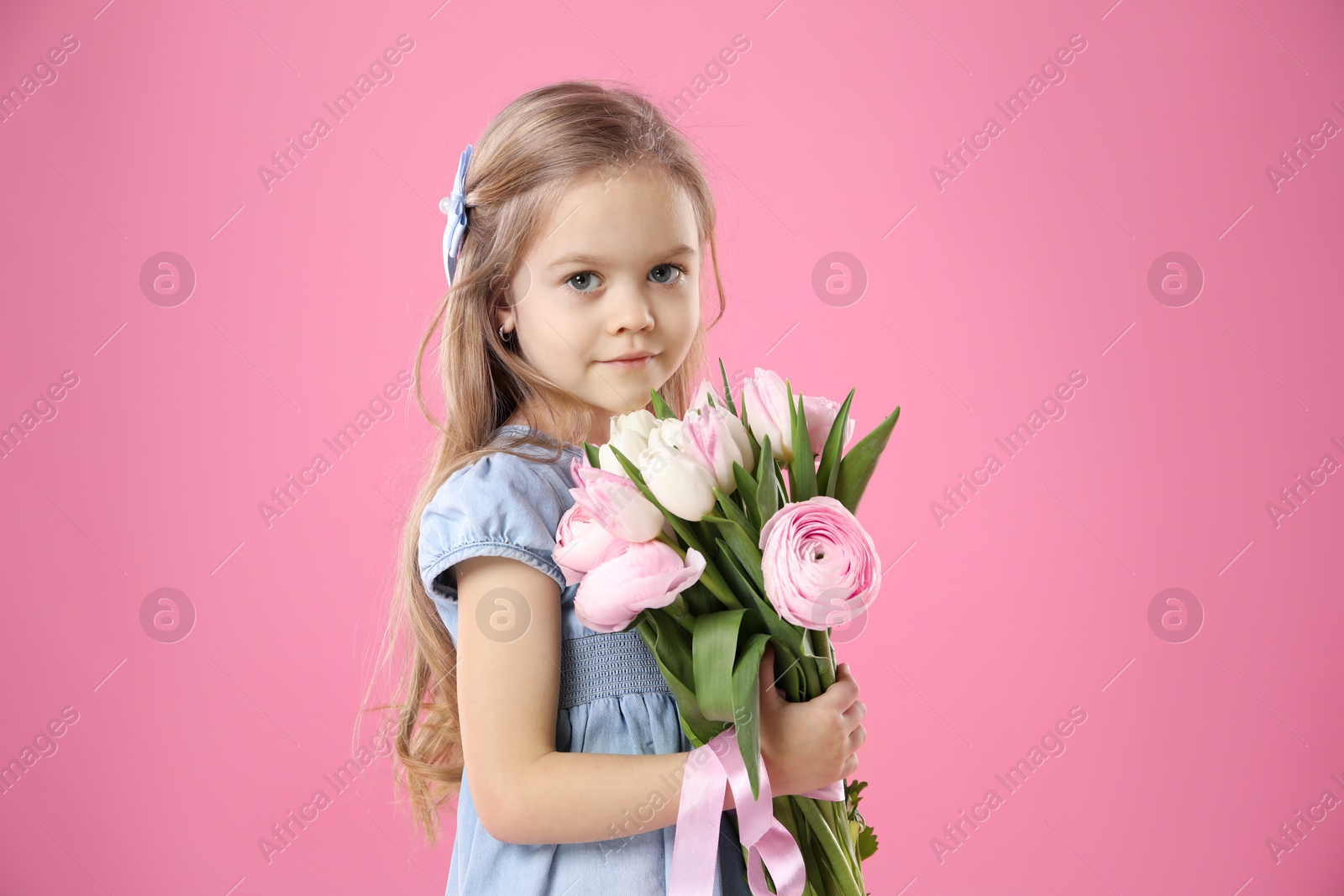 Photo of Cute little girl with bouquet of beautiful spring flowers on pink background