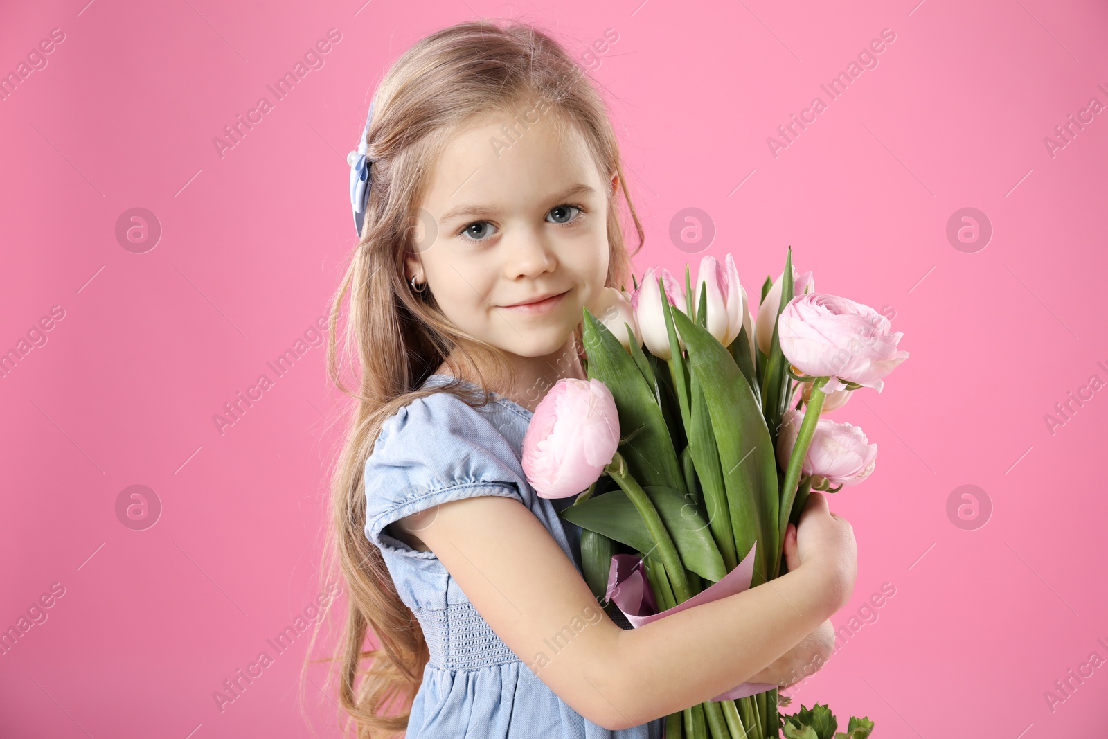 Photo of Cute little girl with bouquet of beautiful spring flowers on pink background