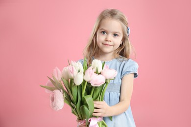 Photo of Cute little girl with bouquet of beautiful spring flowers on pink background