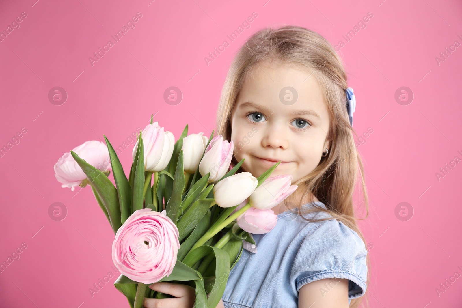 Photo of Cute little girl with bouquet of beautiful spring flowers on pink background