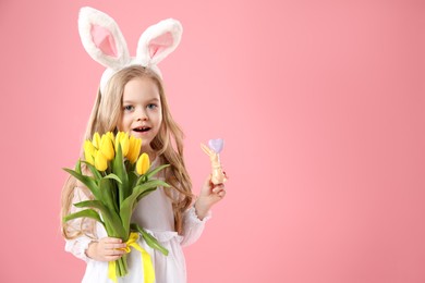 Photo of Cute little girl with bunny ears and tulips on pink background, space for text. Easter celebration