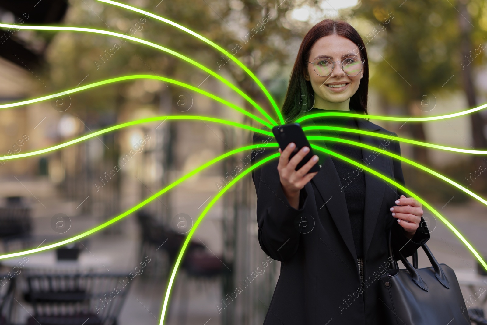 Image of Happy woman using mobile phone outdoors. Bright lines coming out of device symbolizing high speed internet