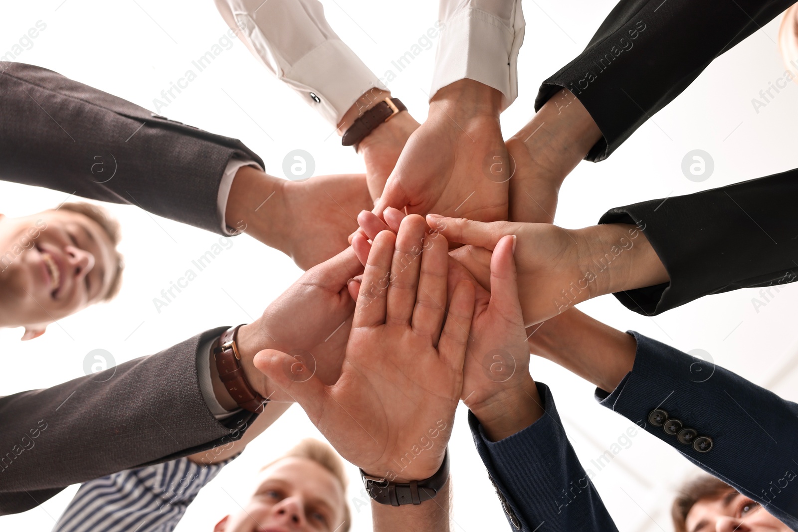 Photo of Teamwork. Group of people joining hands together indoors, bottom view