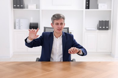 Photo of Man showing something at desk in office