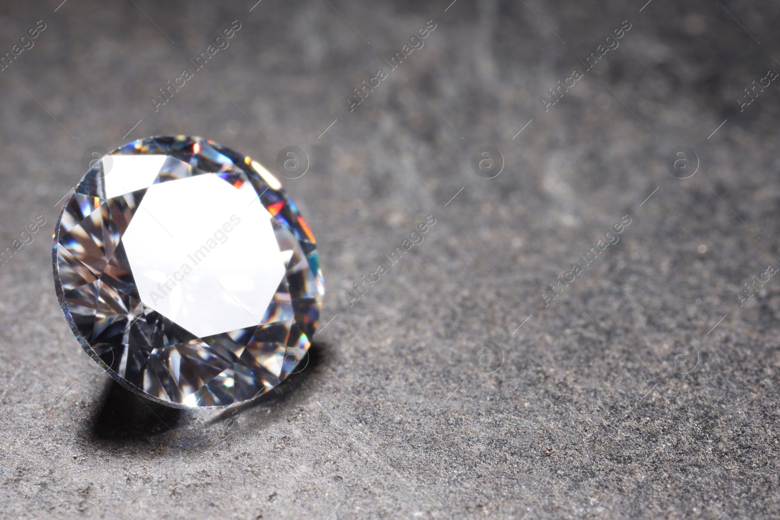 Photo of Beautiful shiny gemstone on stone, closeup. Space for text