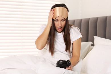 Photo of Overslept woman with alarm clock in bed at home