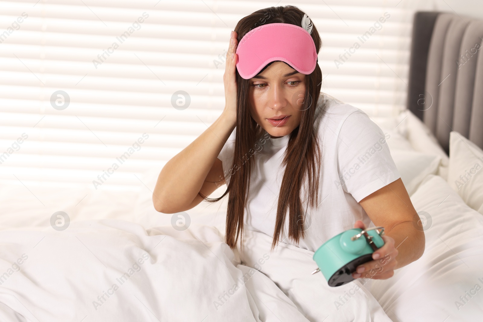 Photo of Overslept woman with alarm clock in bed at home