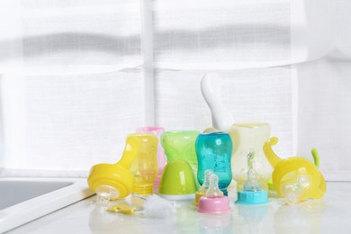 Photo of Clean feeding bottles drying on counter indoors. Space for text