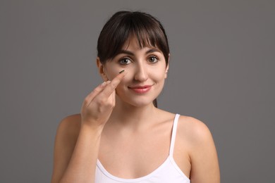 Photo of Young woman with green color contact lens on grey background