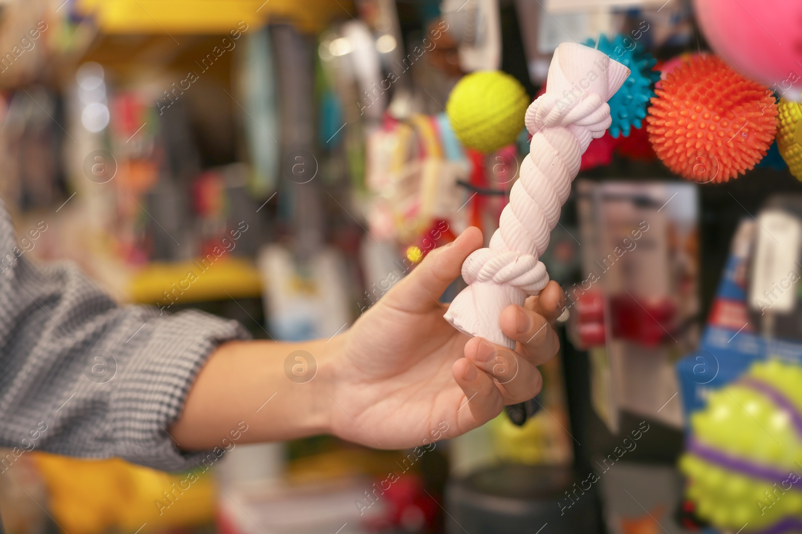 Photo of Woman choosing toy in pet shop, closeup