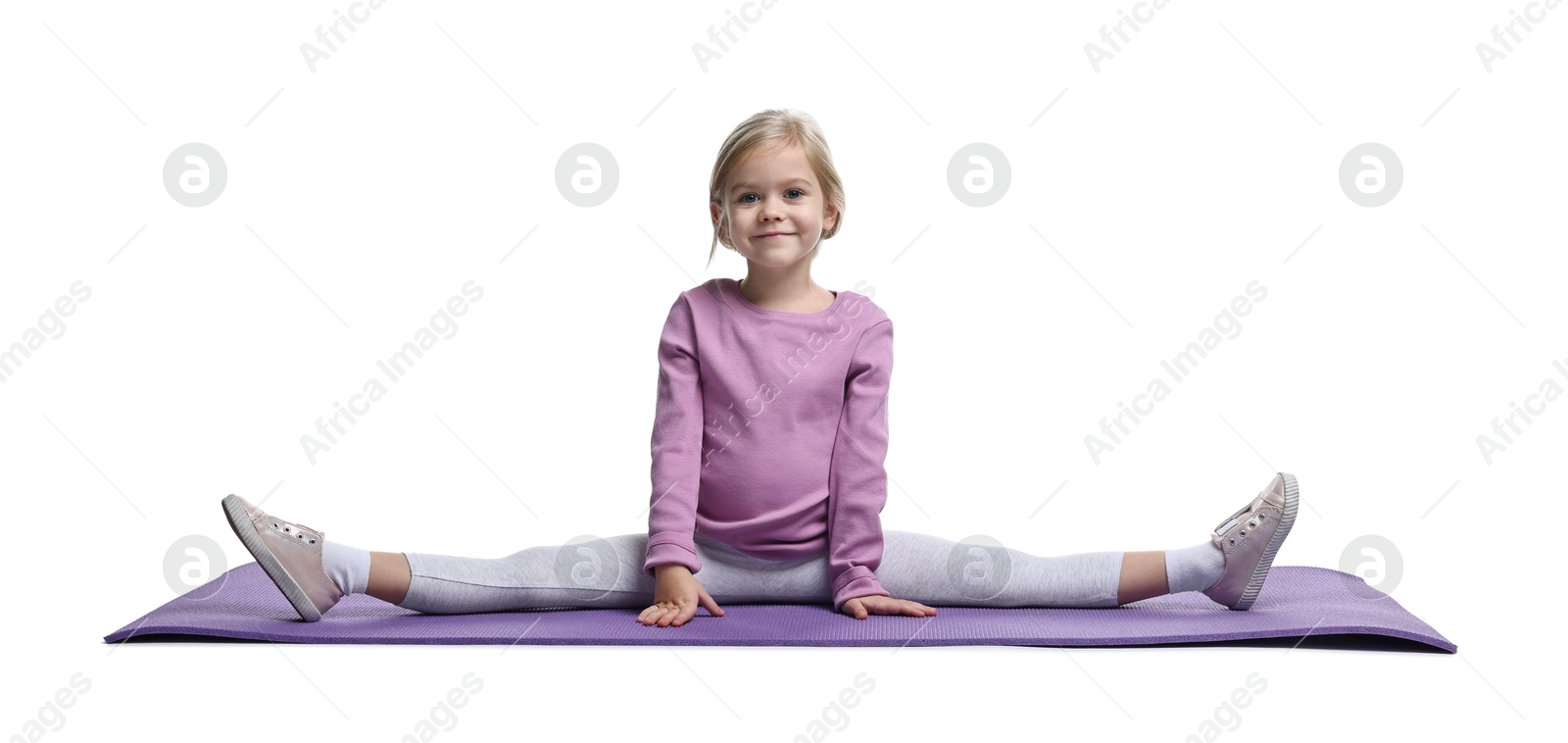 Photo of Little girl exercising on fitness mat against white background. Sport activity