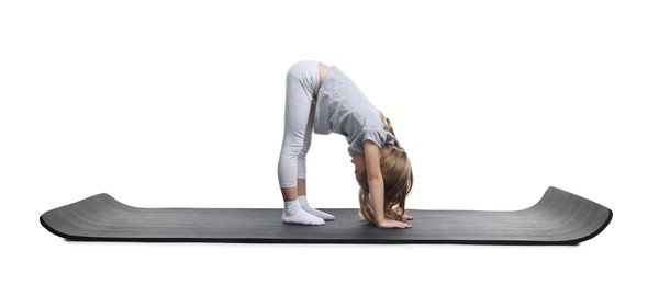 Photo of Little girl exercising on fitness mat against white background. Sport activity