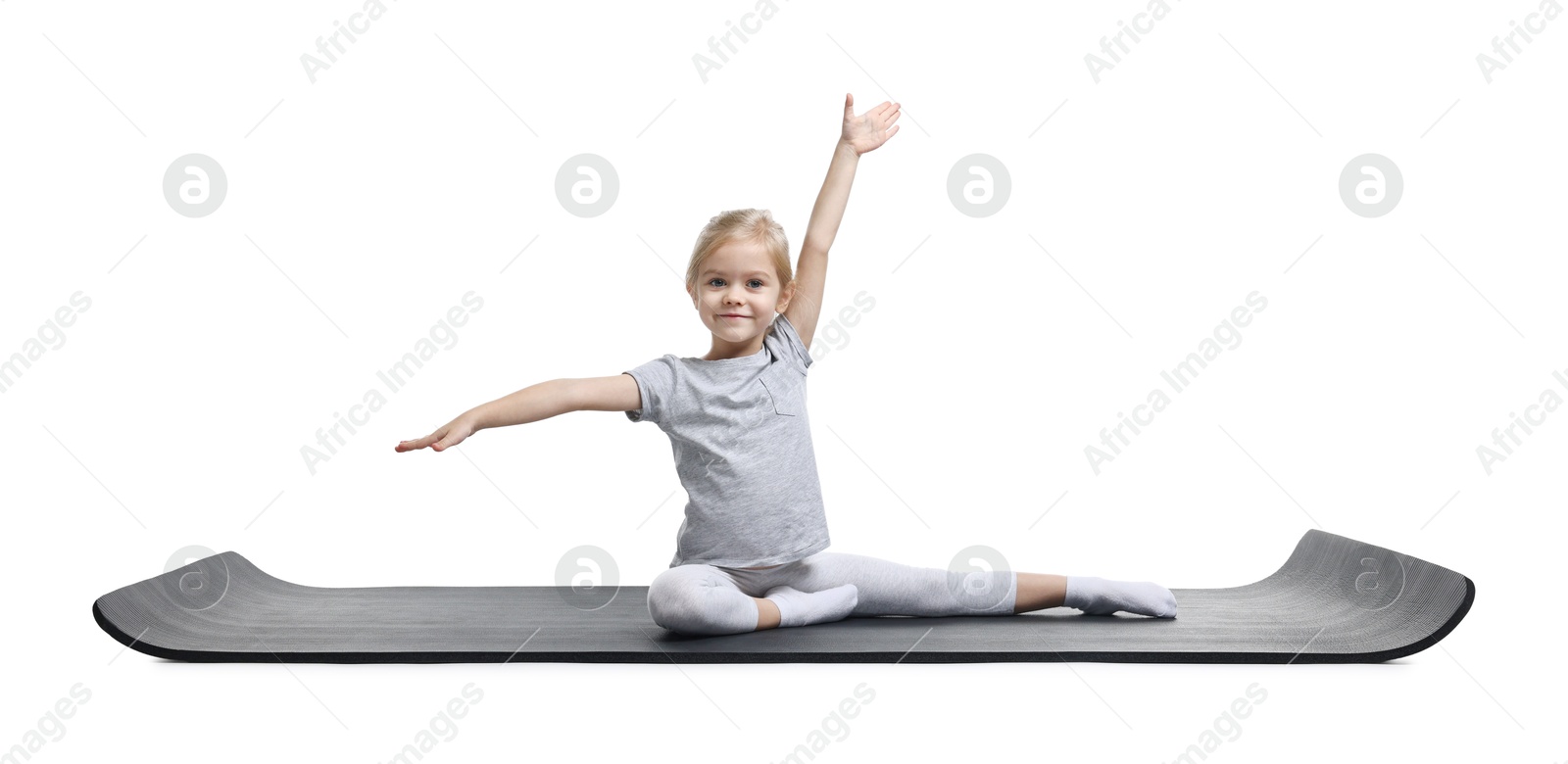 Photo of Little girl exercising on fitness mat against white background. Sport activity