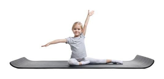 Photo of Little girl exercising on fitness mat against white background. Sport activity