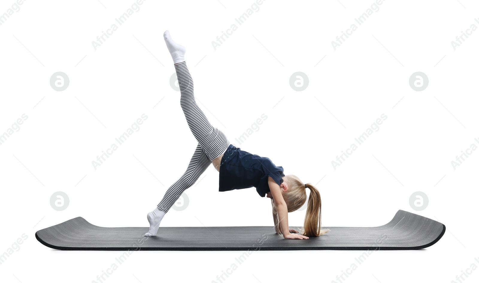 Photo of Little girl exercising on fitness mat against white background. Sport activity