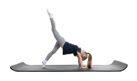 Photo of Little girl exercising on fitness mat against white background. Sport activity