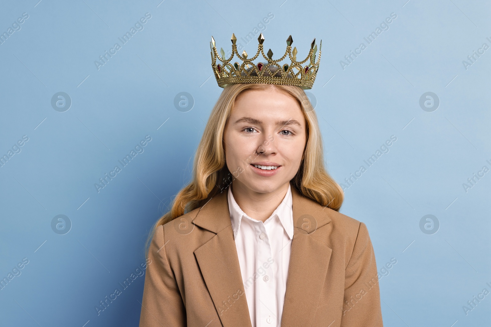 Photo of Smiling businesswoman in elegant crown on light blue background