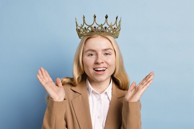 Photo of Happy businesswoman in elegant crown on light blue background