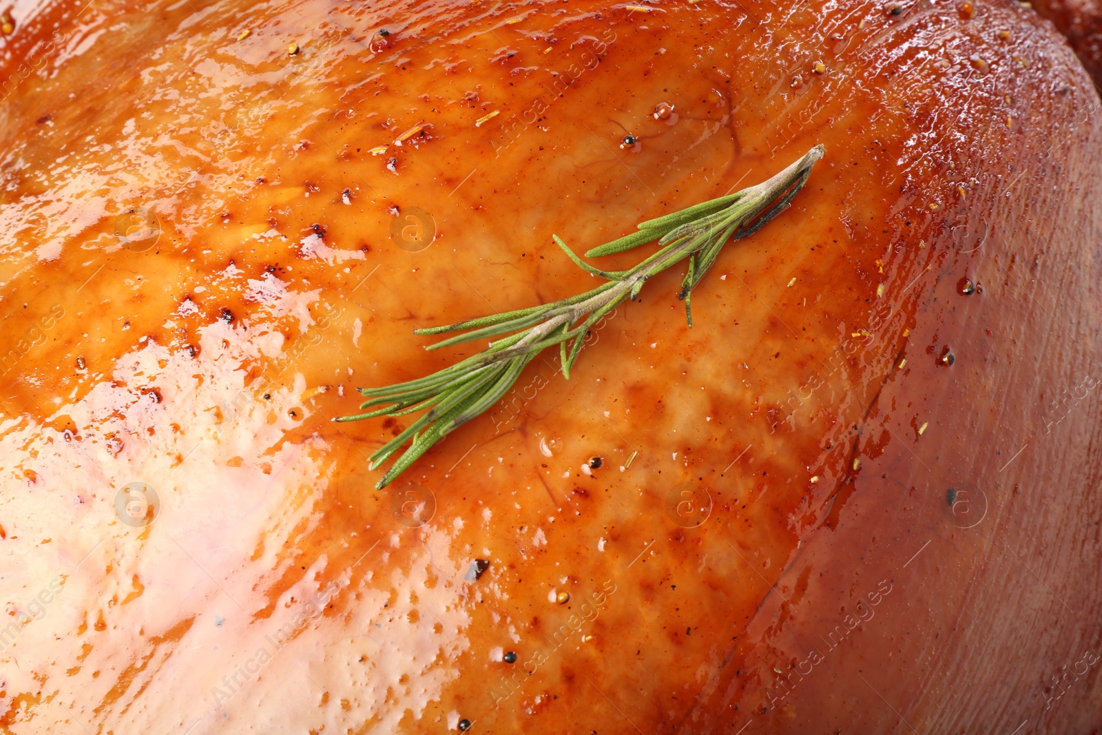 Photo of Delicious freshly baked turkey and rosemary as background, closeup