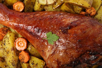 Photo of Baked turkey drumstick and vegetables as background, closeup