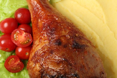 Photo of Baked turkey drumstick with mashed potato and tomatoes as background, closeup