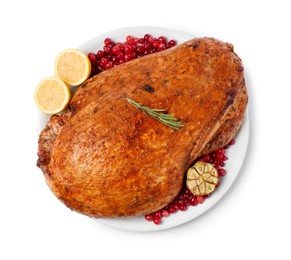 Photo of Piece of delicious baked turkey with cranberries, lemon slices and garlic isolated on white, top view